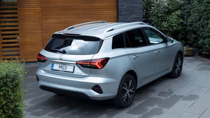 a silver car parked in front of a wood wall