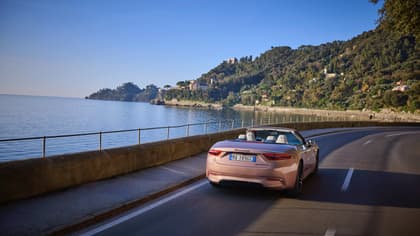 une voiture roulant sur une route près d'un plan d'eau