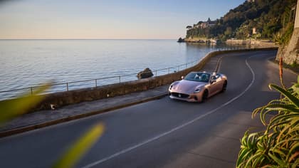 une voiture roulant sur une route près d'un plan d'eau