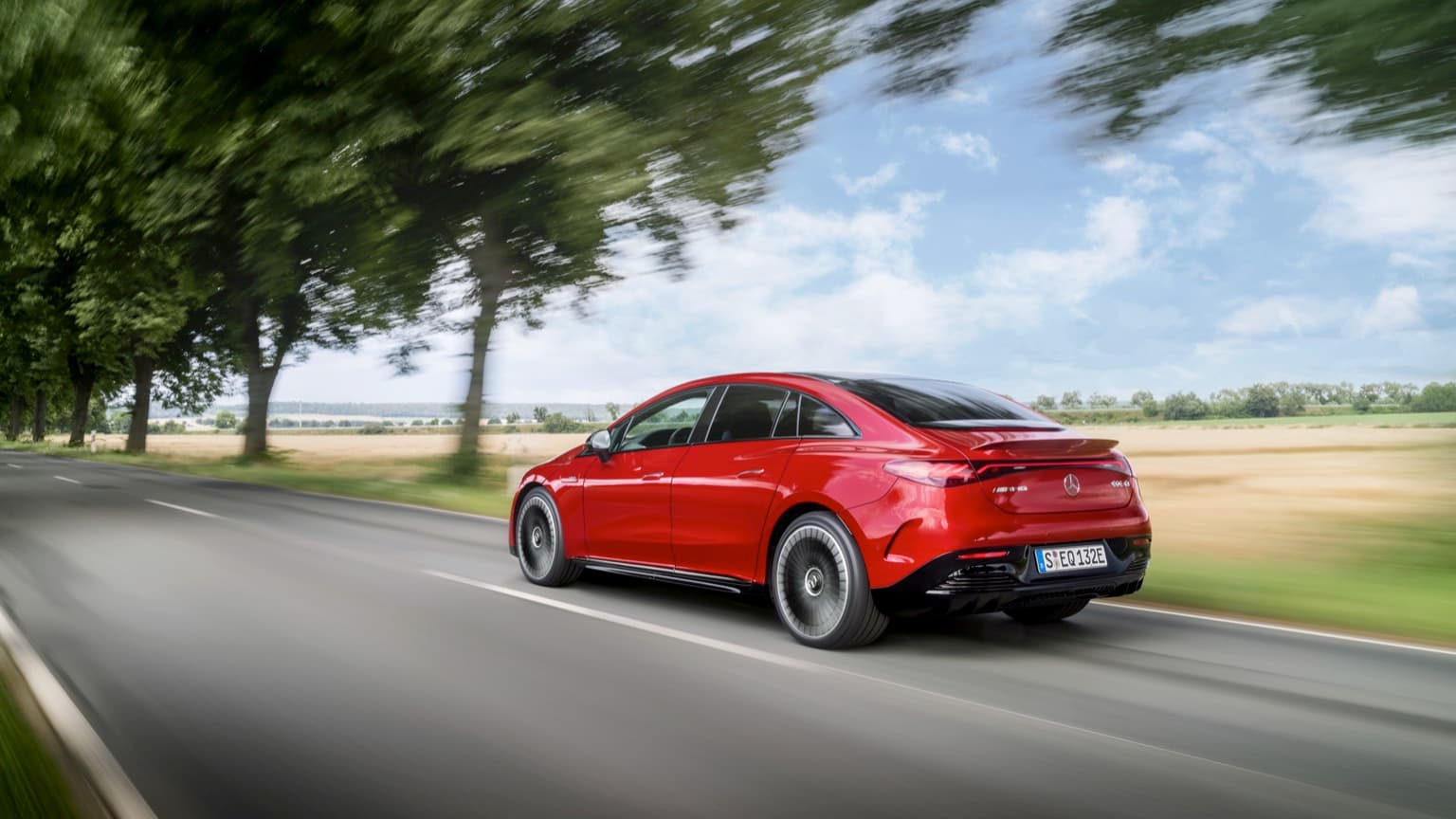 une voiture rouge roulant sur une route