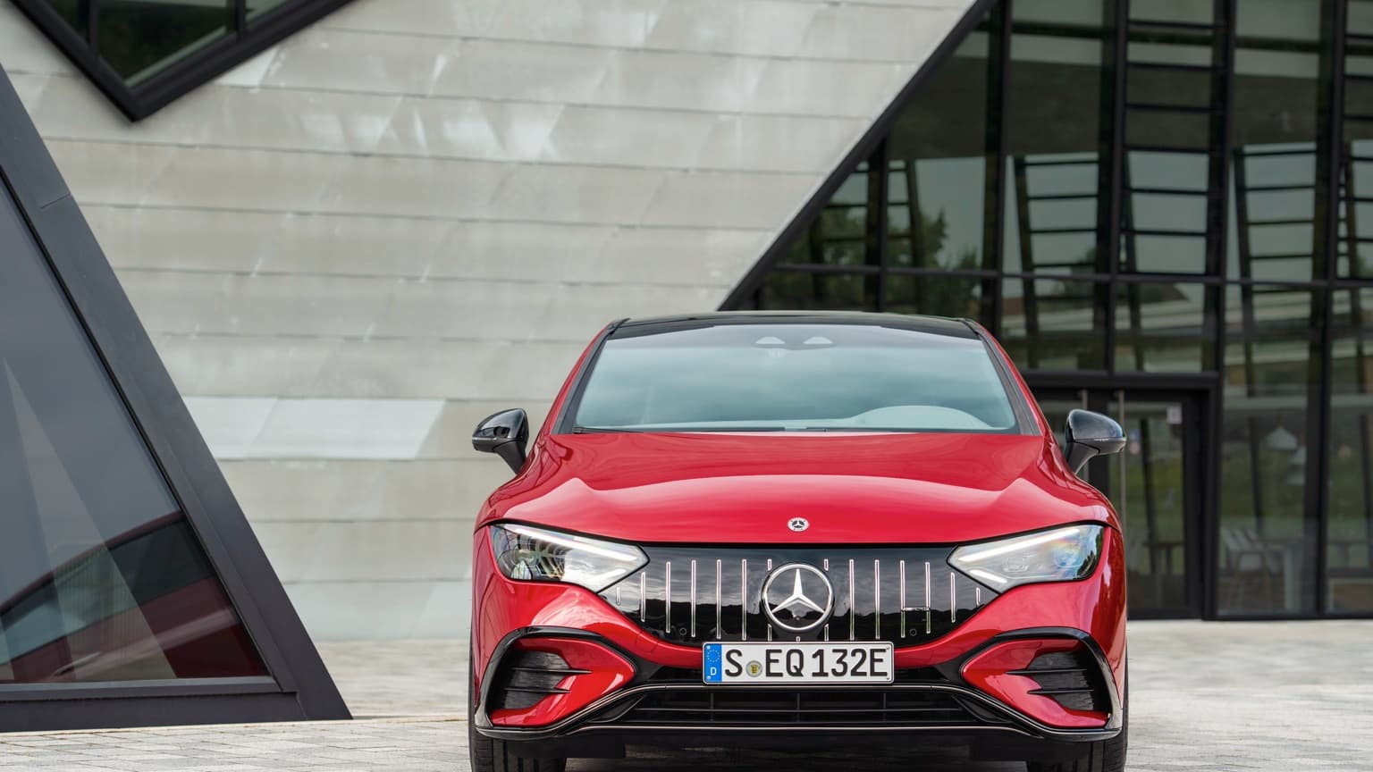 une voiture rouge garée devant un bâtiment
