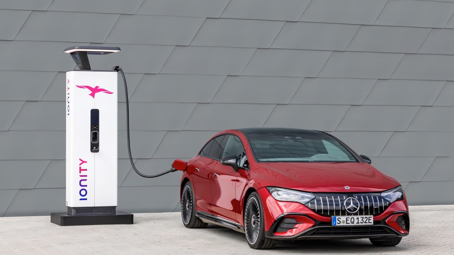une voiture rouge avec un panneau blanc et un logo noir et rose