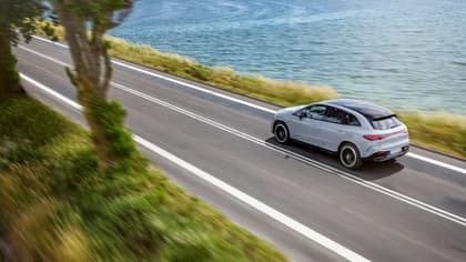 une voiture roulant sur une route près d'un plan d'eau