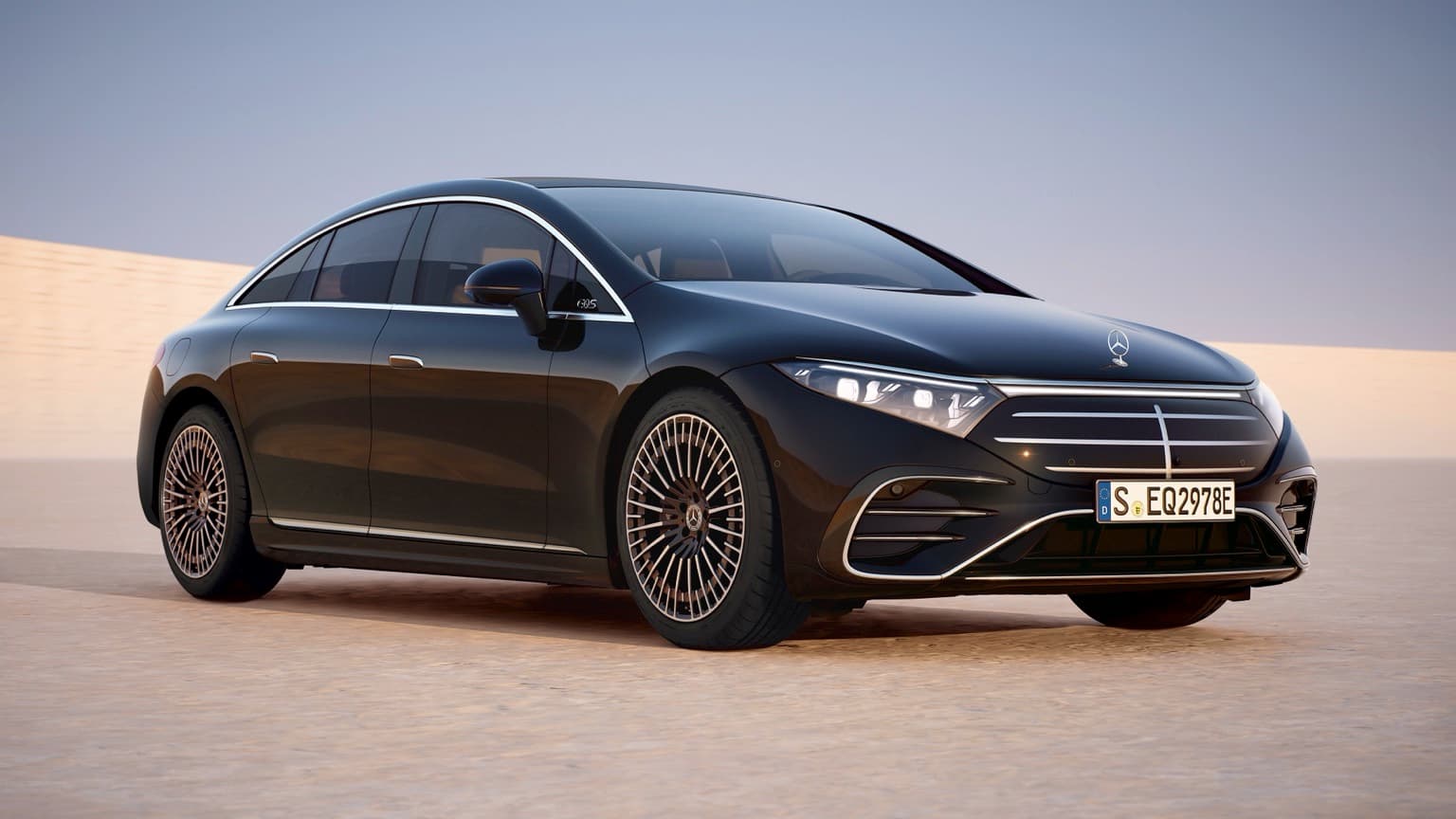 a black car parked on a sandy surface