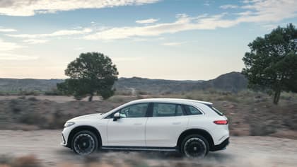 une voiture blanche roulant sur un chemin de terre