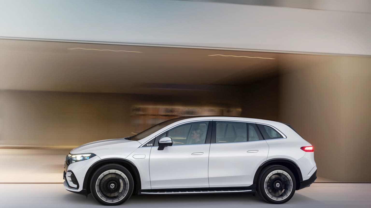 a white car driving through a garage