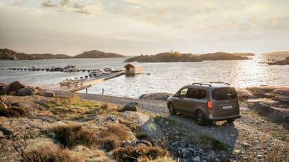 une voiture garée sur un rivage rocheux près d'un quai