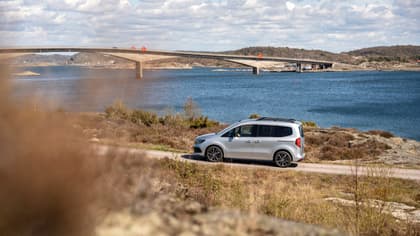 une voiture sur une route près d'un plan d'eau