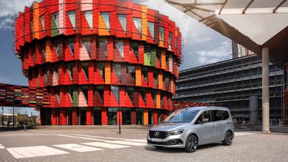 une camionnette argentée garée devant un bâtiment multicolore