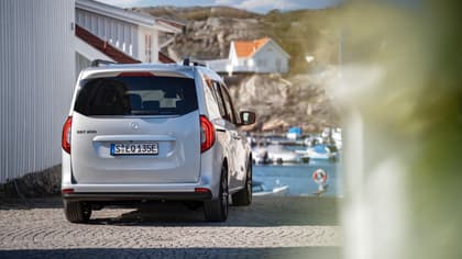 une voiture garée sur une route près d'un plan d'eau