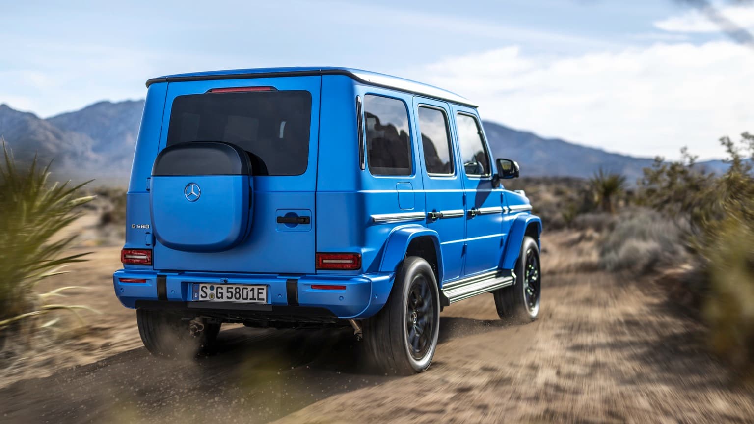 une voiture bleue roulant sur un chemin de terre