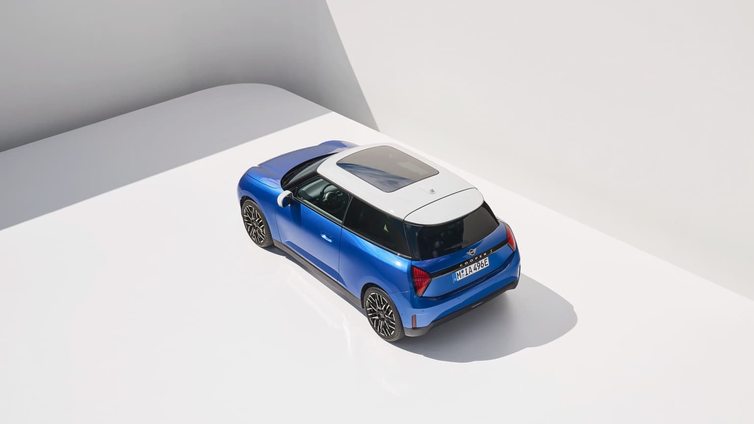 une voiture bleue garée dans une pièce blanche