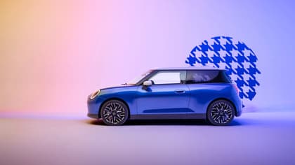 a blue car parked in front of a blue and pink background