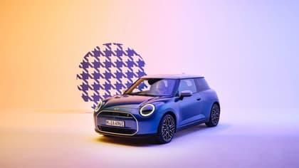 a blue car parked in front of a checkered wall