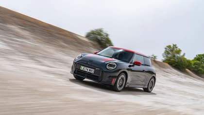 a black and red car driving on a dirt road