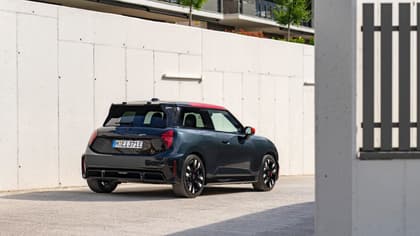 a black car parked in front of a white wall
