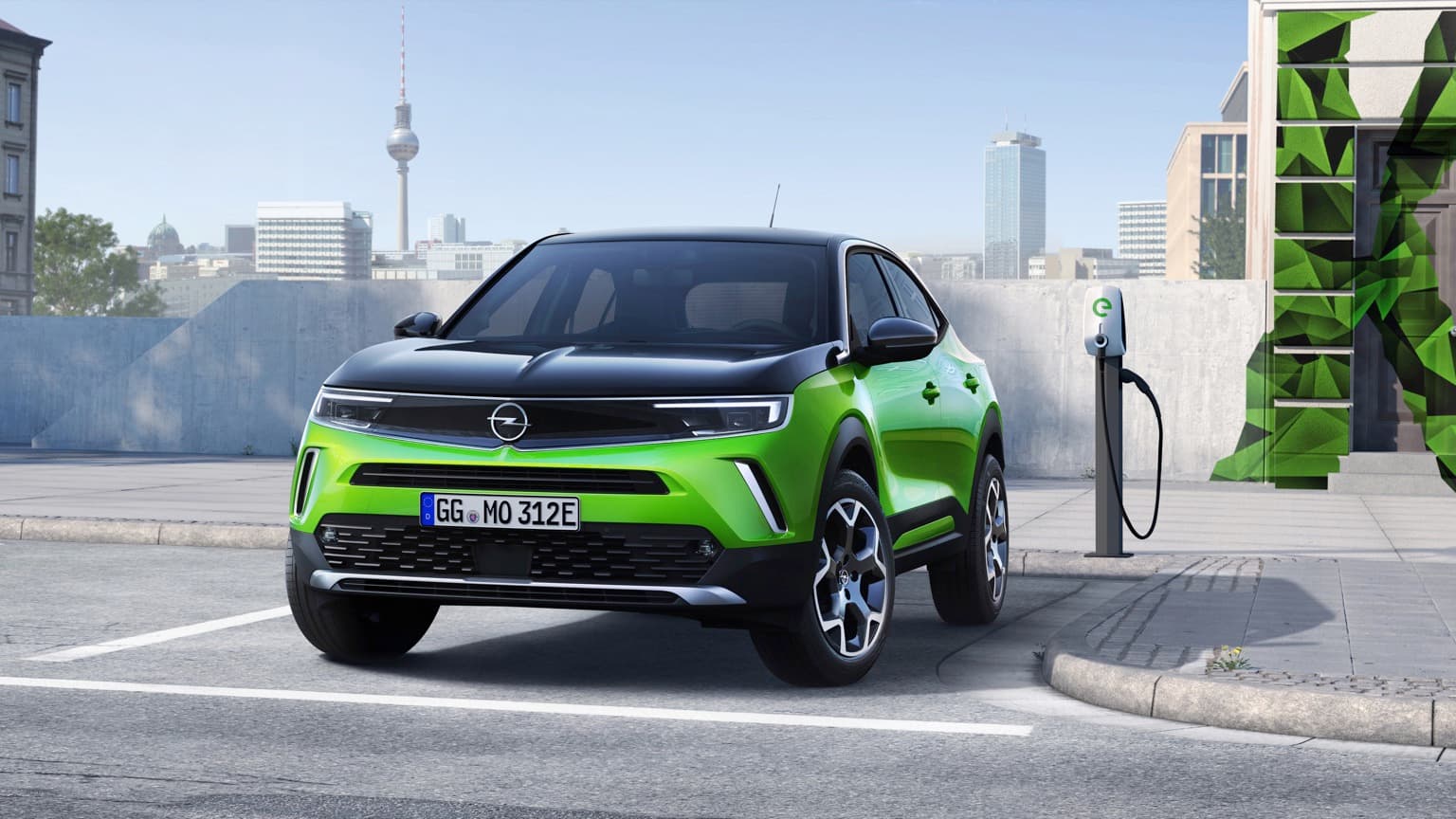 une voiture verte garée à une station de recharge