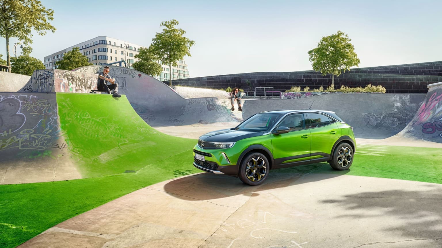 un suv vert et noir garé sur un skate park