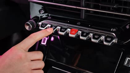 a finger pressing a button on a car dashboard