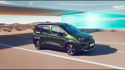 une camionnette verte roulant sur une route