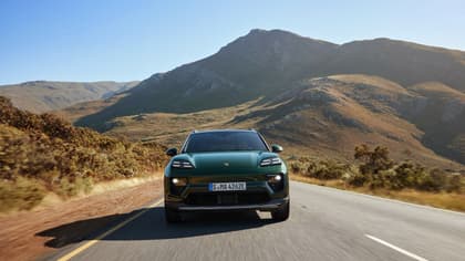 une voiture roulant sur une route avec des montagnes en arrière-plan