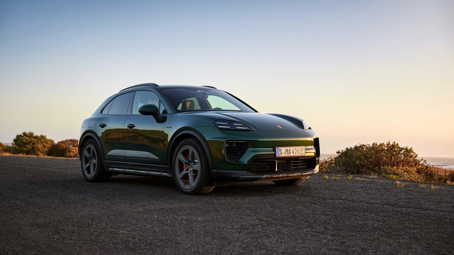 a green car parked on a road