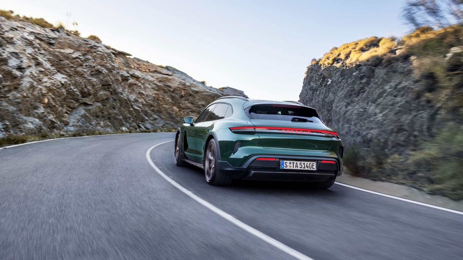 a green car driving on a road