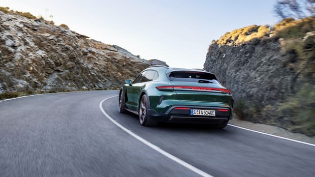 a green car driving on a road
