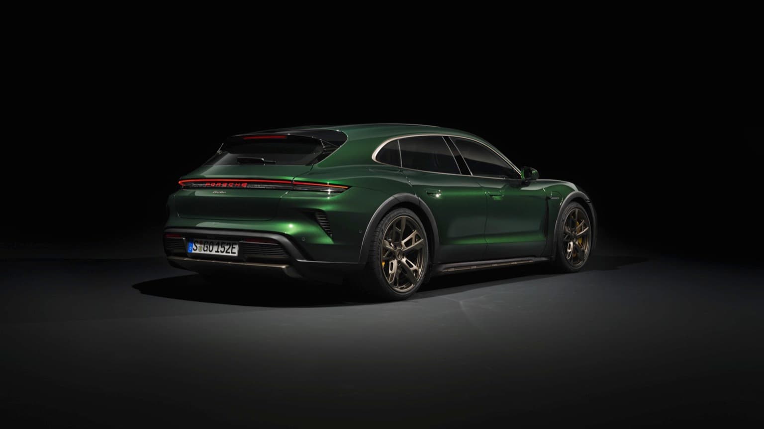 a green sports car in a dark room