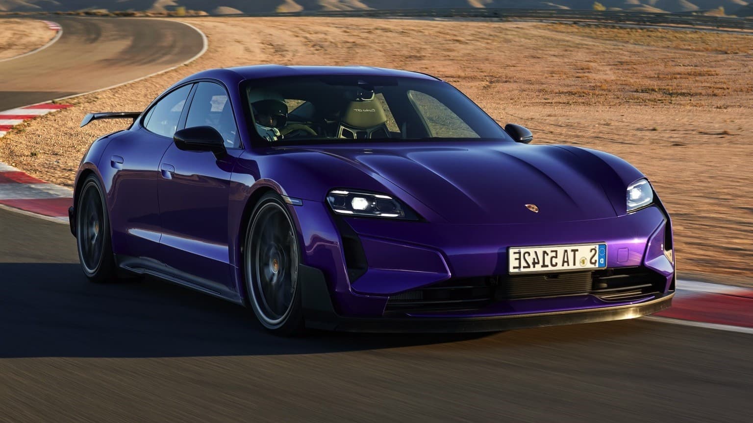 a purple sports car driving on a road