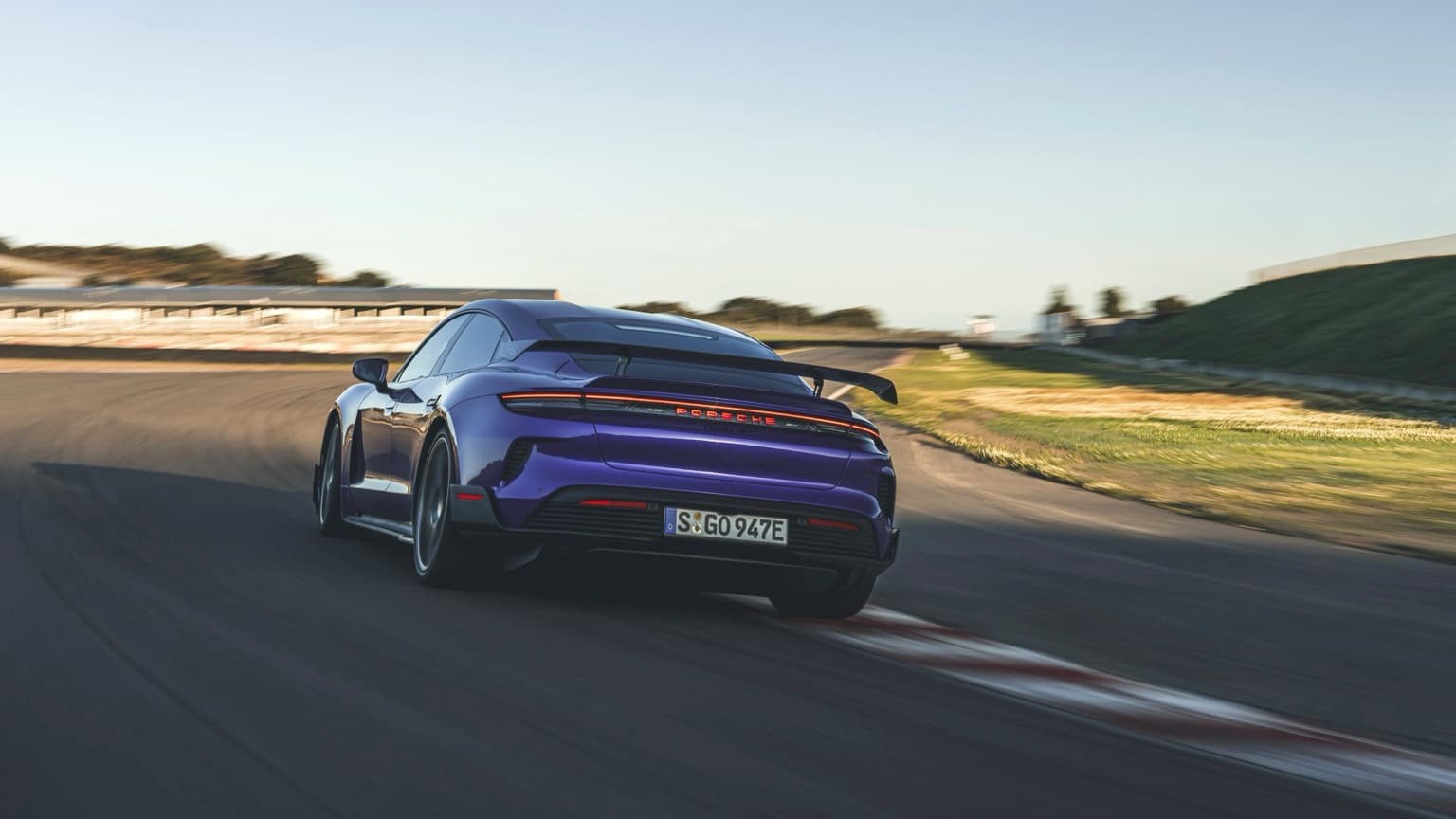 a purple sports car driving on a road