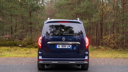 une camionnette bleue garée sur une route avec des arbres en arrière-plan