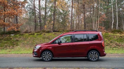 une camionnette rouge sur une route avec des arbres en arrière-plan
