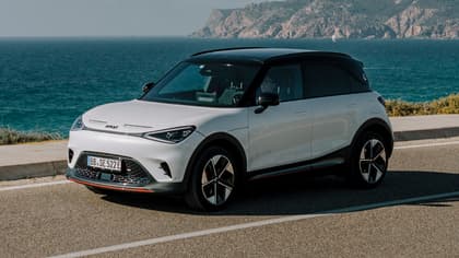 a white car parked on a road next to water