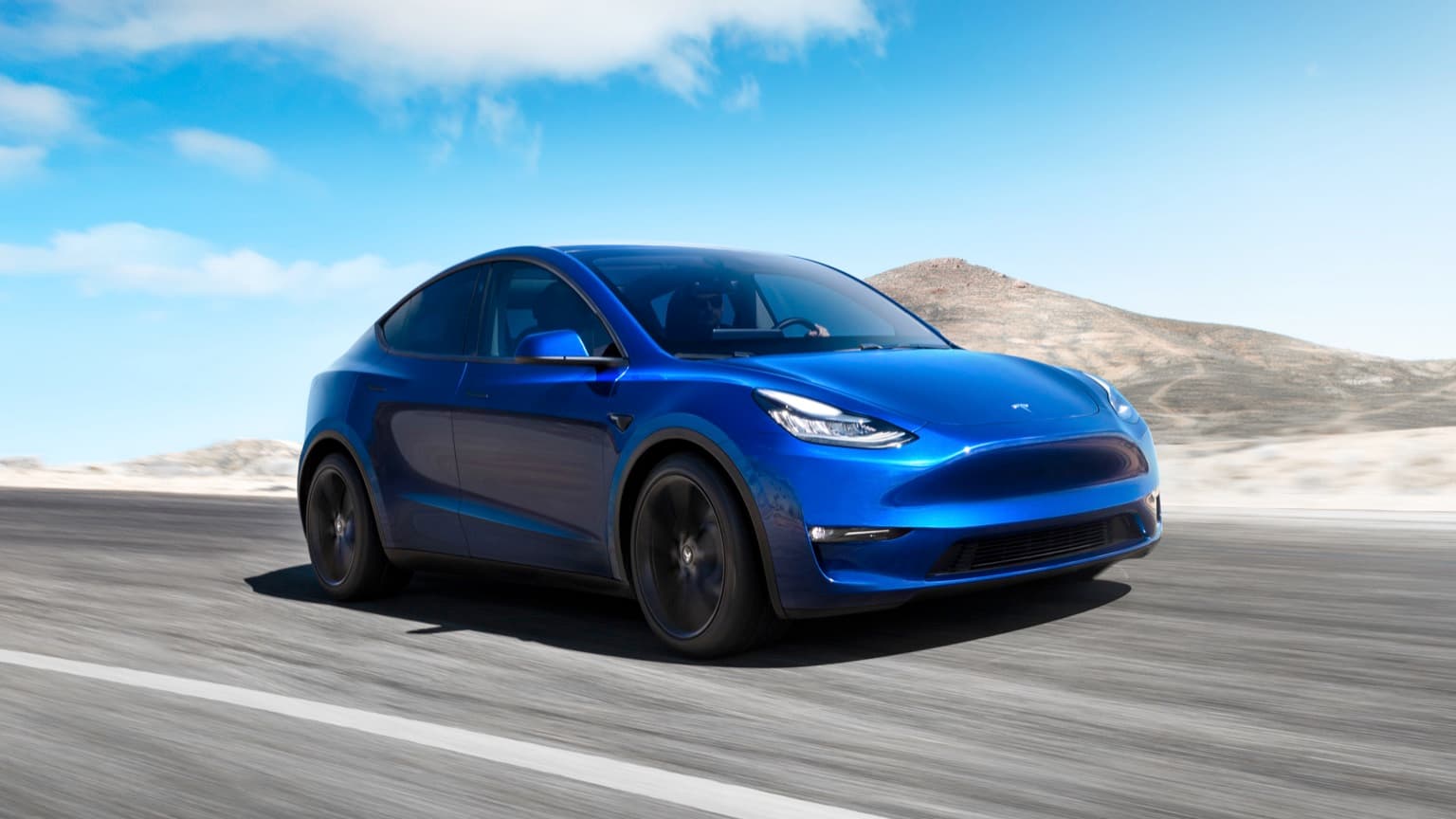 a blue car driving on a road