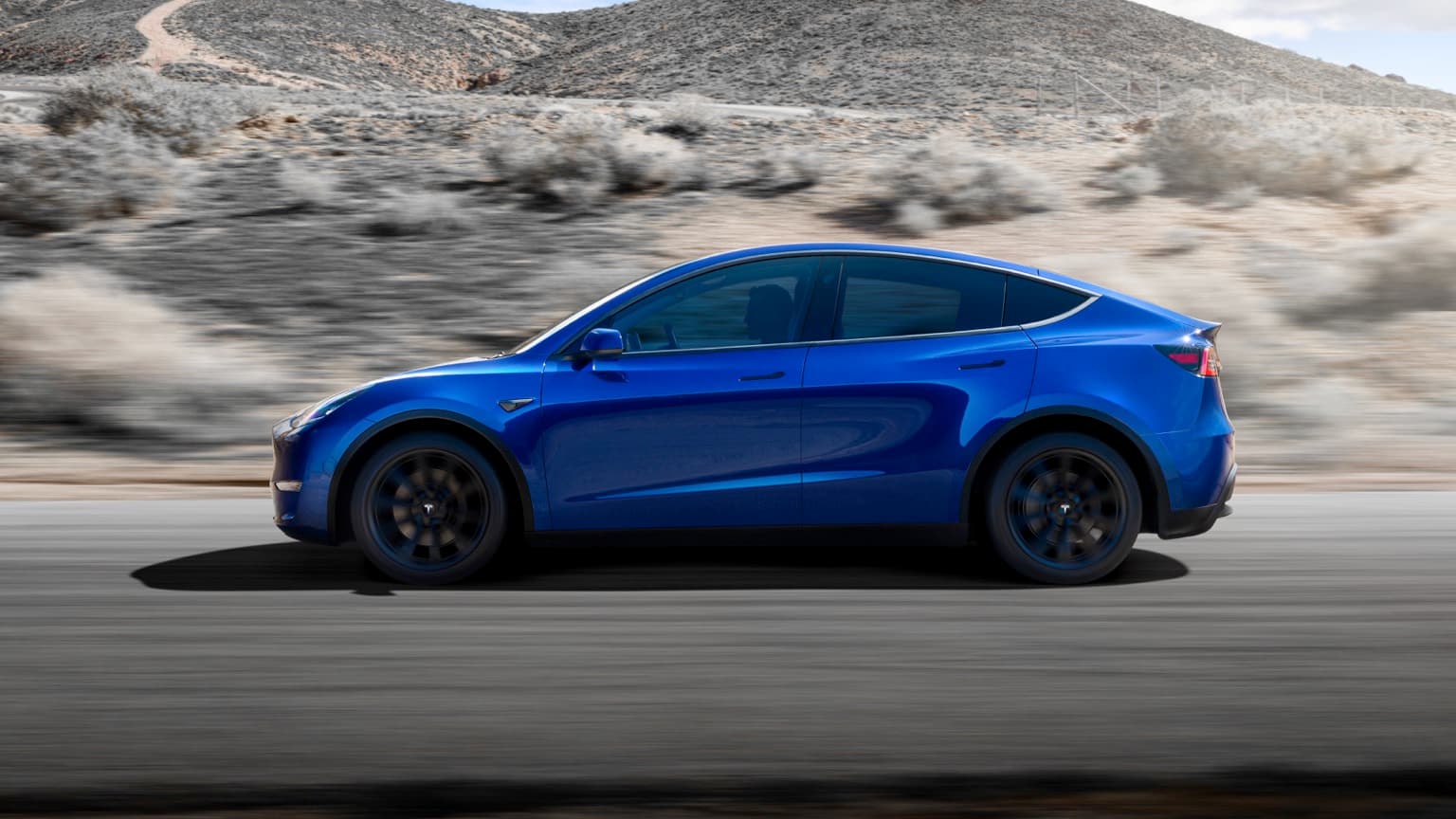 a blue car driving on a road