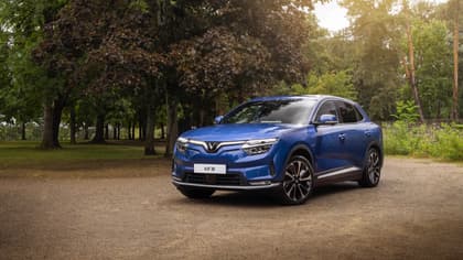 une voiture bleue garée sur un chemin de terre