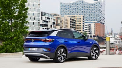 une voiture bleue garée devant des bâtiments