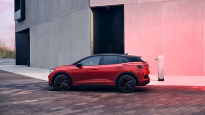 une voiture rouge garée à côté d'un bâtiment