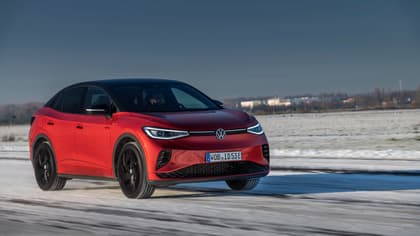 a red car driving on a snowy road