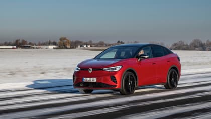 a red car driving on a snowy road