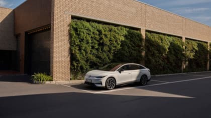 une voiture blanche garée devant un bâtiment en briques