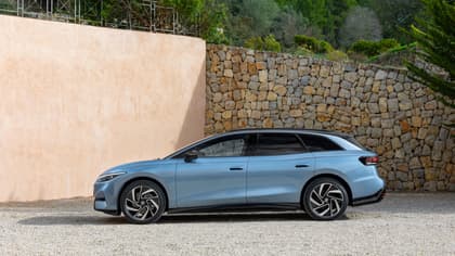 une voiture bleue garée devant un mur de pierre