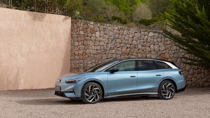 une voiture bleue garée devant un mur de pierre