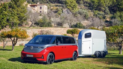 une camionnette rouge avec une remorque blanche sur l'herbe