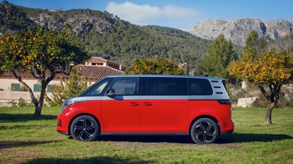 une camionnette rouge garée sur l'herbe près d'une maison