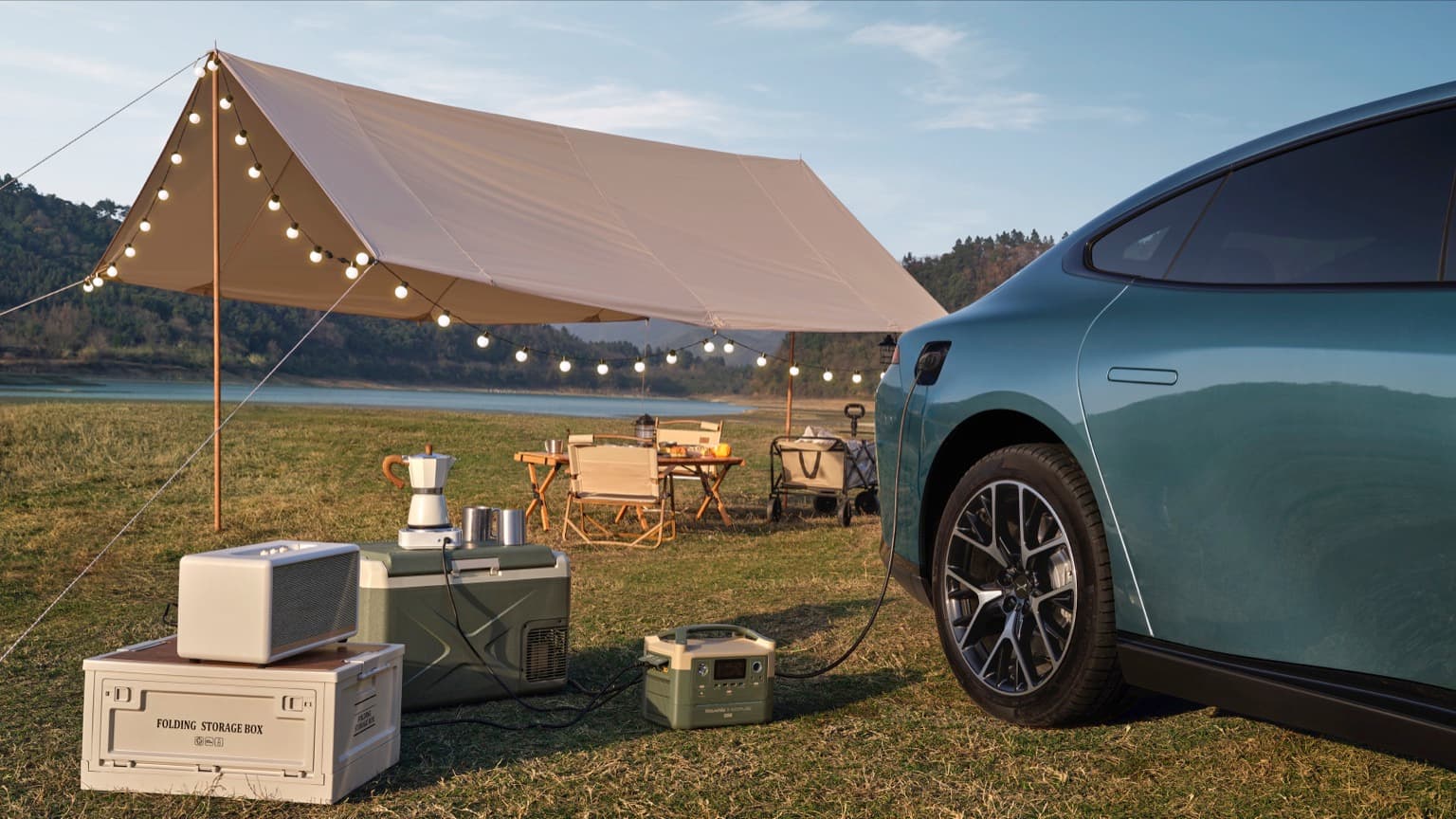 a car parked in a field with a tent and chairs