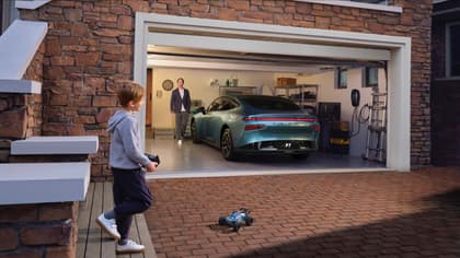 un garçon marchant dans un garage avec une voiture dans le garage