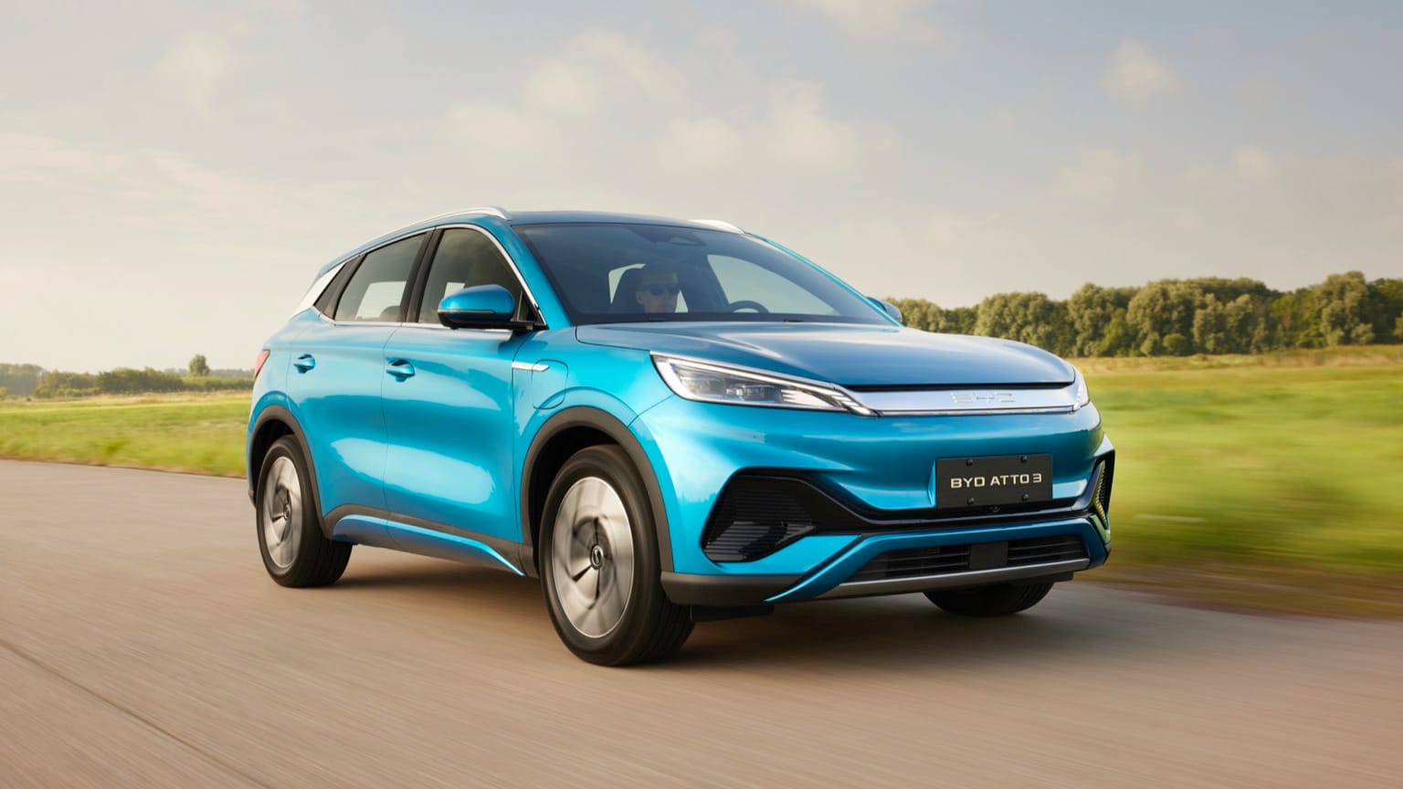 une voiture bleue roulant sur une route