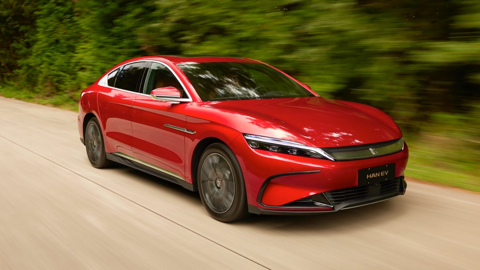 une voiture rouge roulant sur une route